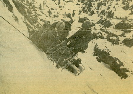 After being given first aid, the 'injured' climber is lowered down the slope in a liter by rescuers After being given first aid, the 'injured' climber is lowered down the slope in a liter by rescuers