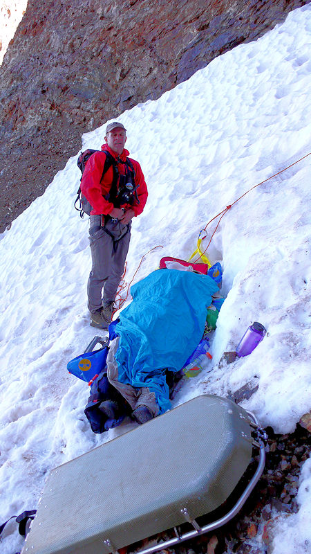 The injured hiker is stabilized on the 40 degree slope, while other team members set up anchors to begin the 1800 foot lowering down the slope The injured hiker is stabilized on the 40 degree slope, while other team members set up anchors to begin the 1800 foot lowering down the slope