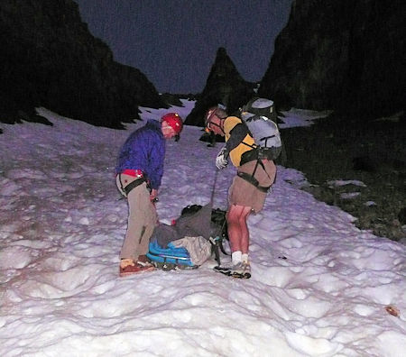 Descending the snow field while attending to the injured hiker Descending the snow field while attending to the injured hiker