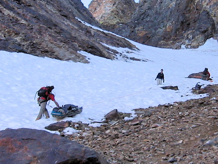 Belaying the victim in litter down the snow slope Belaying the victim in litter down the snow slope