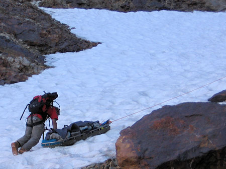 Belaying the victim in litter down the snow slope Belaying the victim in litter down the snow slope
