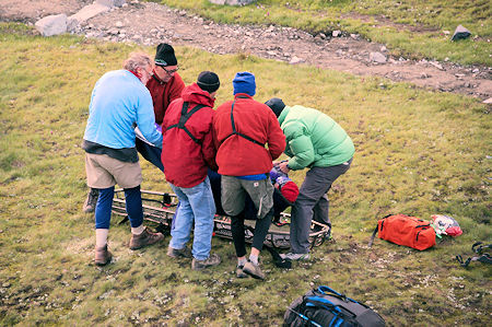 SAR members with help from nearby camper place injured hiker in litter in preparation for transporting to the helicopter SAR members with help from nearby camper place injured hiker in litter in preparation for transporting to the helicopter