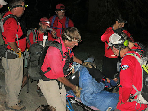 Covering injured hiker with sleeping bag to keep warm Covering injured hiker with sleeping bag to keep warm