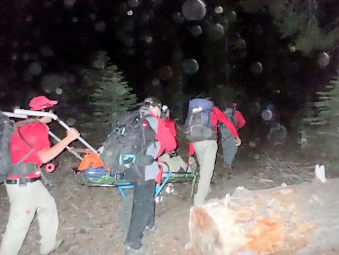 Moving wheeled liter up the trail in the dark Moving wheeled liter up the trail in the dark